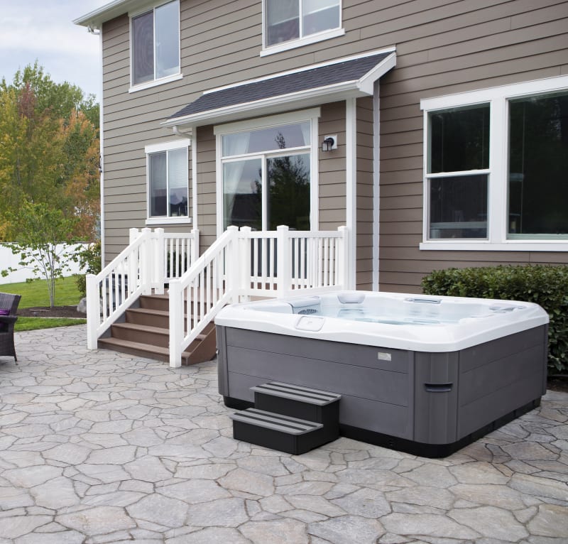 A hot tub sits outside a house